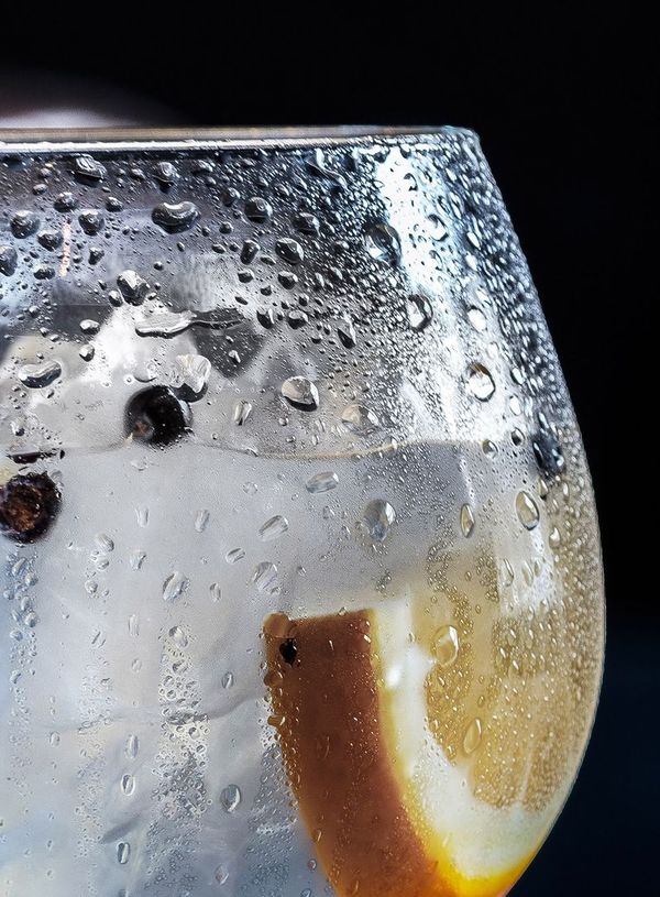 Ein Glas mit Gin Tonic und einer Zitrone drinnen
