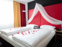 Das Senator Hotel Wien Kuschelzimmer, ein Doppelbett mit Rosen drauf und einer Love Box