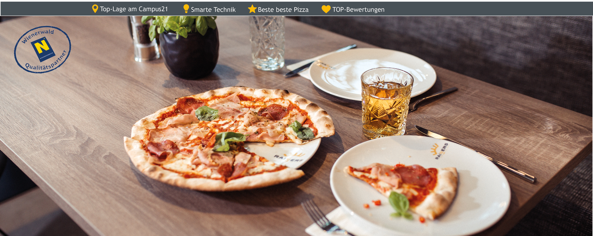 Eine Pizza Margharita mit einer schnitte auf dem Teller und einem Glas Eistee neben dem Teller im Rainers21 Restaurant Ventuno 